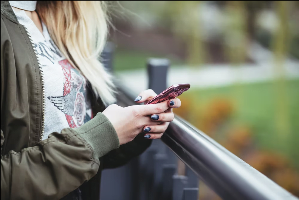 A woman reading a text message from a business
