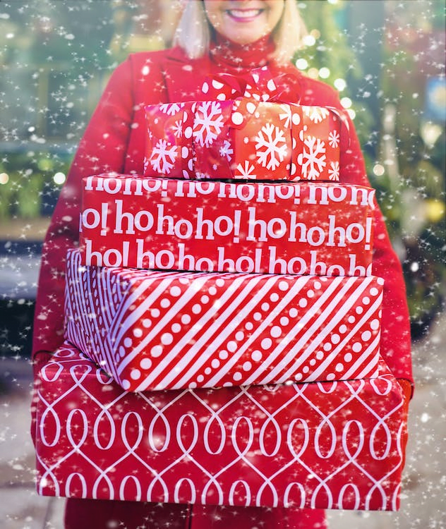 A woman carrying Christmas gifts