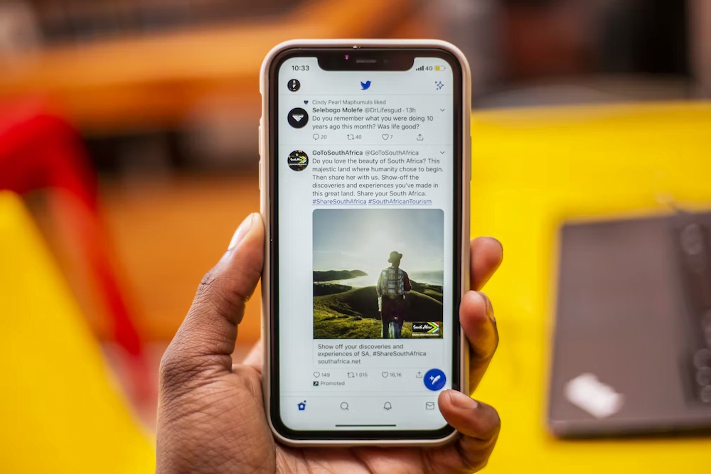 A person using Twitter on their iPhone